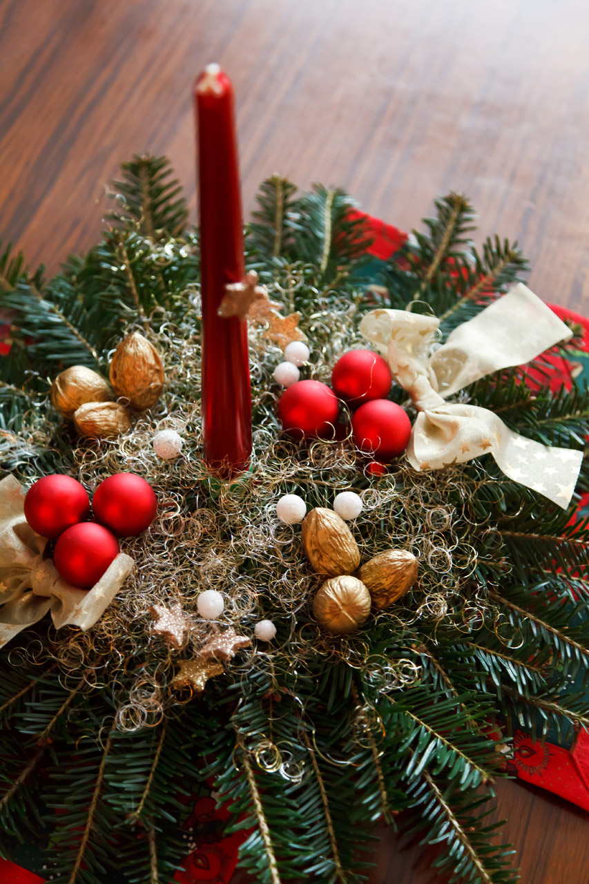 Christmas decoration with thin red candle on a table