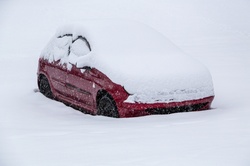 Photo of a car totally buried in snow and surrounded by nothing but snow