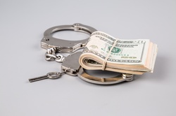 Handcuffs and money on gray background