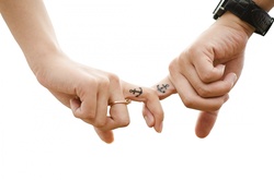 Man and woman holding hands by fingers with anchor tattoo