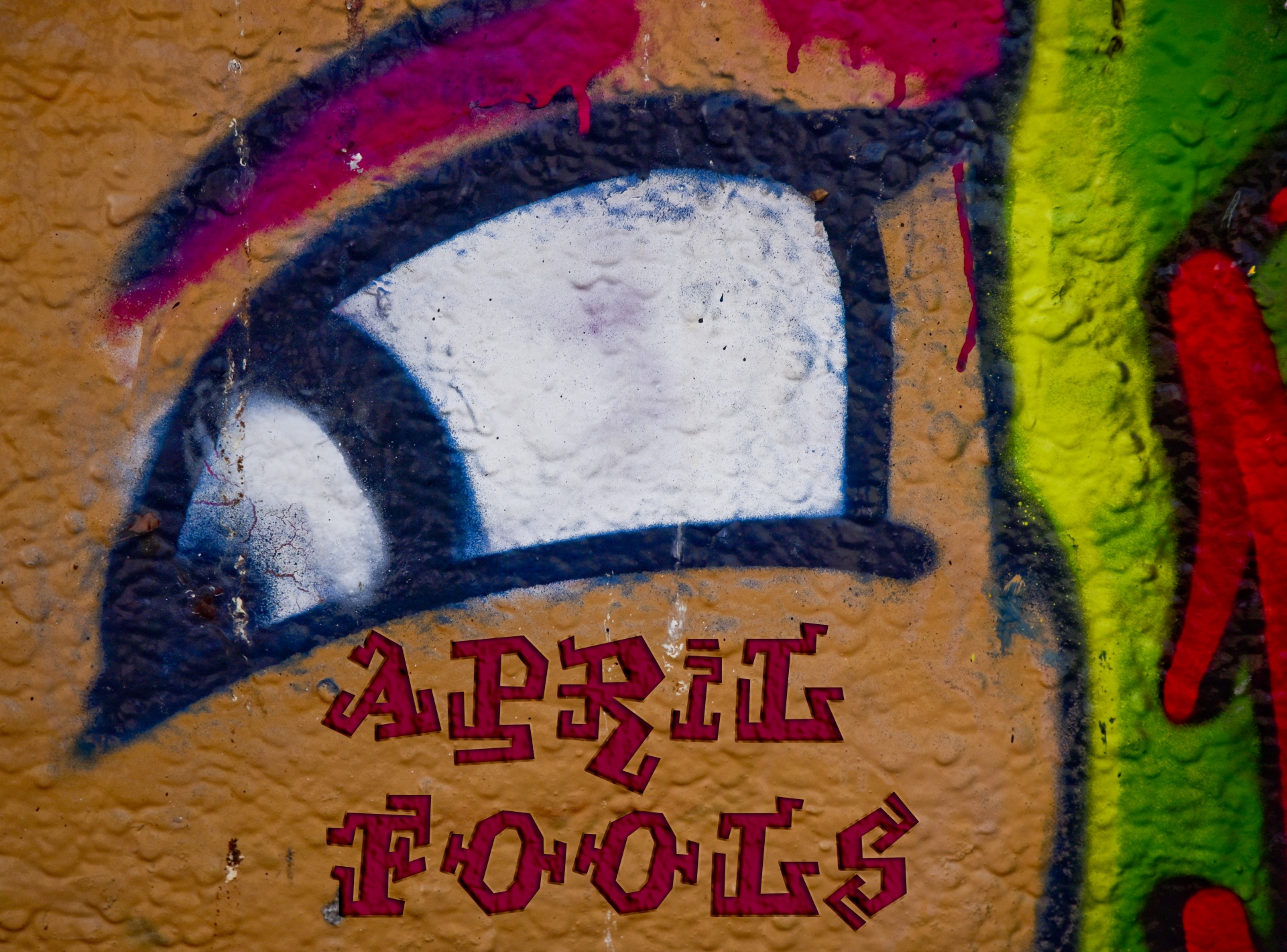 Graffiti on a Wall for April Fools Day with orange, green, red and black stucco