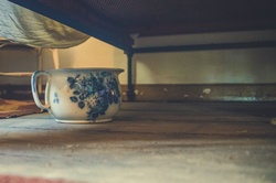 Old ceramic chamber pot under the bed