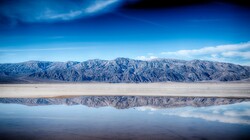 Stream of blue water sits in the bottom of Death Valley National Park in the Mojave Desert.