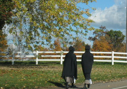 Two young Amish girls walking down the road