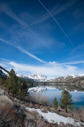 Clear blue water of a lake in the Sierra Nevada mountains with snow.