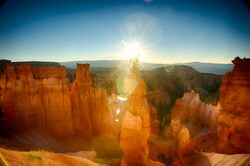 Sun rises over the tall orange rock formations of Bryce Canyon National Park.