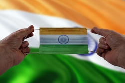 Hands holding face mask with India flag