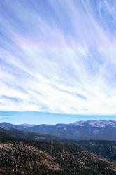 A photo Sierra Nevada Mountains Sky with clouds and rainbow