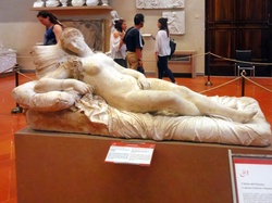 A sculpture of a reclining nude woman with drapery.