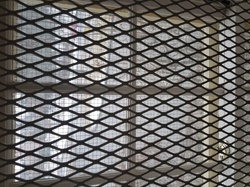 Window pane closed with two layers of metal barricades.