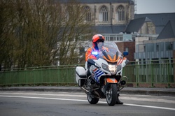 Police on motorcycle precedes the road cycling race, departure in Oudenaarde, Belgium, Tour of Flanders