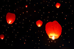 Many sky lanterns floating on dark sky