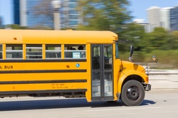 Yellow school bus in motion in the city