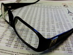 Glasses on a newspaper with stock exchange values