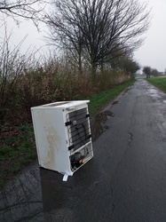 Garbage pollution old refrigerator dumped on dirt road