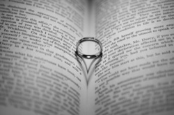 Wedding ring casting a heart-shaped shadow on the book page