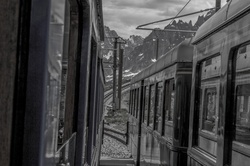 Saint-Gervais-les-Bains, France - June27, 2021 tourists in the train of Tramway du Mont Blanc arriving at the Nid dAigle terminus on a foggy summer day.