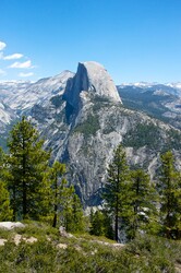 Form of Half Dome in Yosemite stands out against a light blue sky.