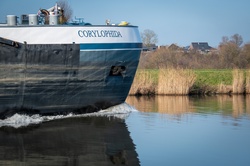 The bow of an inland vessel slides over the water
