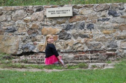Young girl dipping her feet in George Washingtons bath tub Berkeley Springs mineral baths in WV