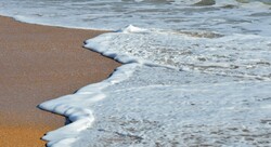 Surf foam washing up on beach at Florida, USA