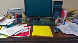 Home office desk with computer and paperwork.