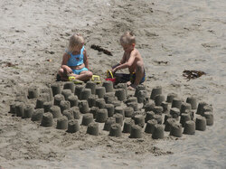 Two children working diligently on a project on Huntington Beach