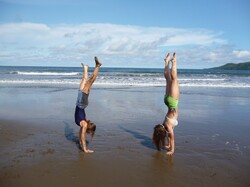 Two girls doing handstands on the beach