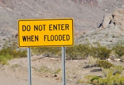 Highway sign in desert that warns drivers to not enter when flooded