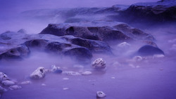 Purple rocks and stones with blurred waves in motion