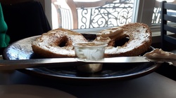 Butter bagel on a plate with cream cheese cup