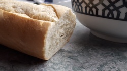 Baguette on a counter with a bowl