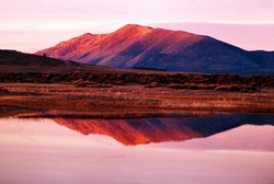 Beautiful sunrise on a mountain that is reflected in the still waters of a lake