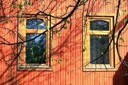 Two windows on a rust-red wood building