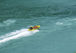 Picture taken in Canada. Yellow jet boat filled with people on the move in the canadian waters going towards the rapids 
