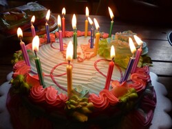 Pastel colored 16th birthday cake with lit candles