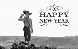 Black and white photo of an tall cowboy sign in desert with Happy New Year greeting