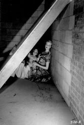 Mother mannequin and a child under a basement lean-to shelter