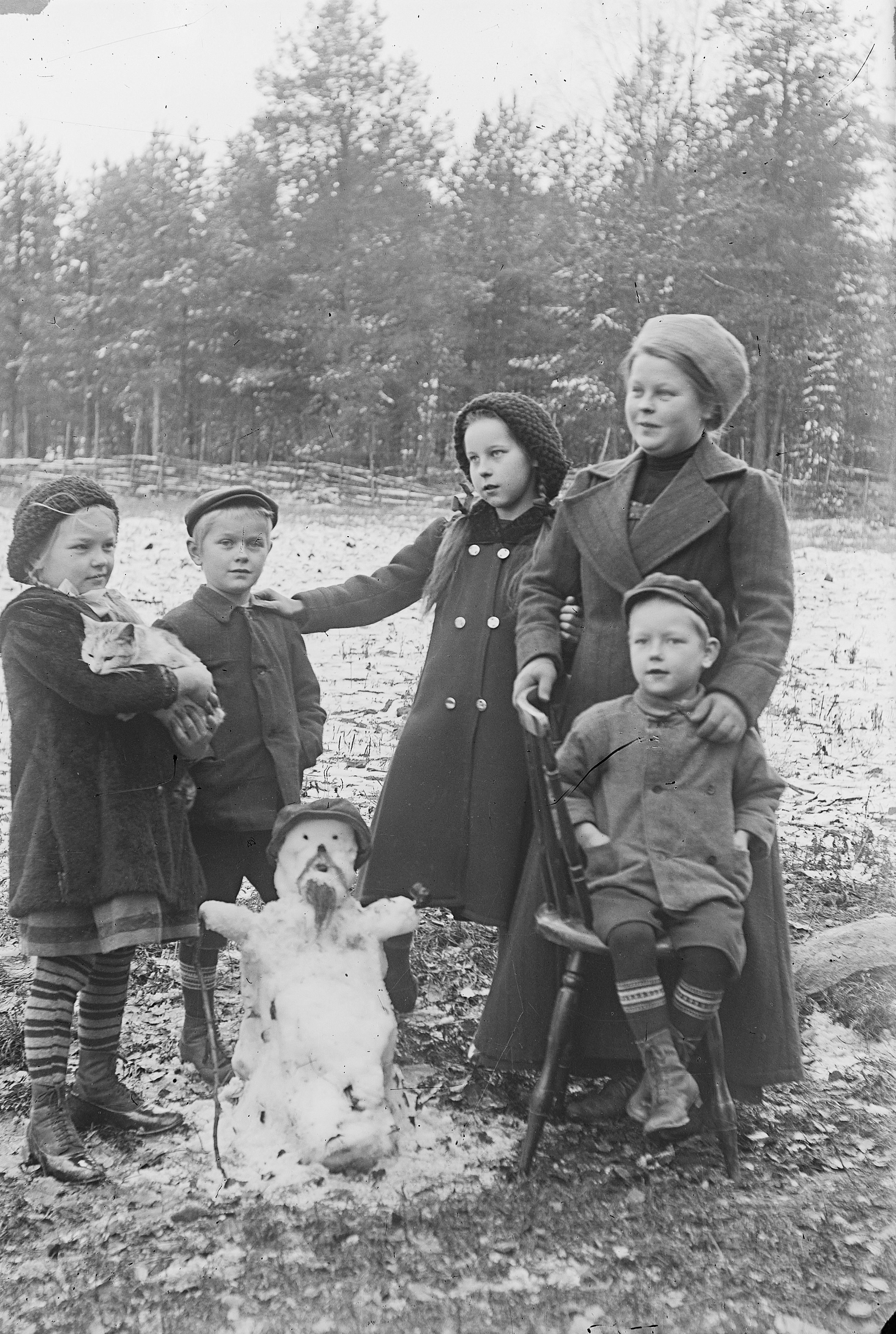 J. H. Aho children and their aunt with a tiny snowman