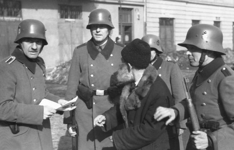 German Ordnungspolizei officers examining a mans