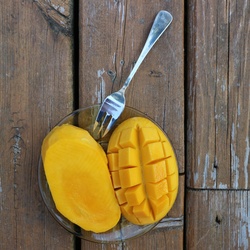 Mango fruit cut with fork on plate