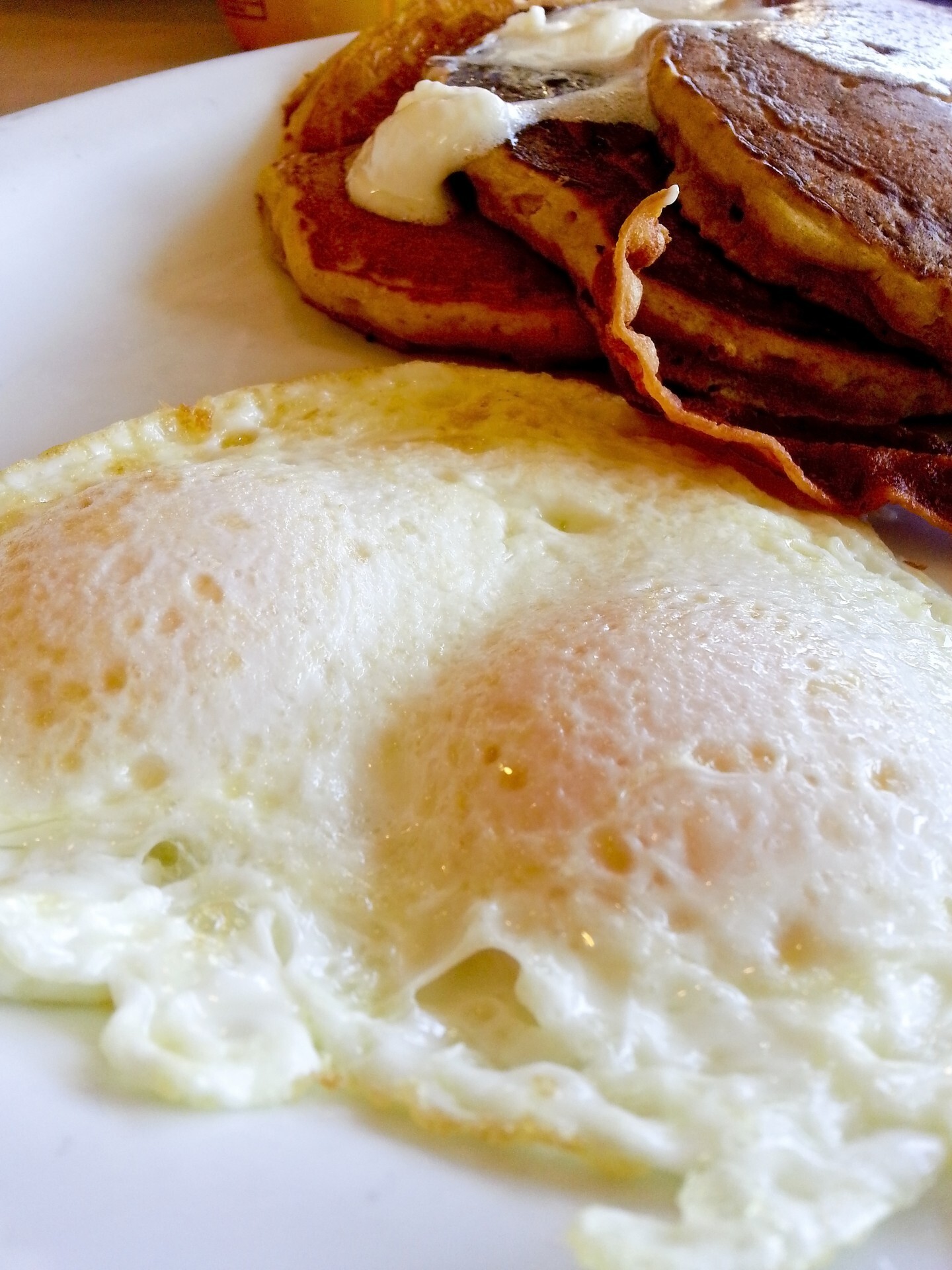 Two eggs over easy, bacon and pancakes