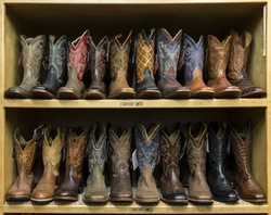 Rows of cowboy boot styles displayed on store shelves