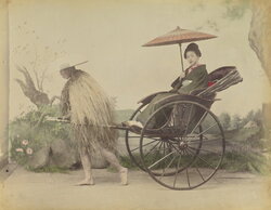 Woman with Parasol Posed Being Pulled in a Jinrikisha by a Man Wearing a Straw Rain Coat