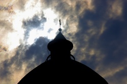 Silhouette of church against clouds