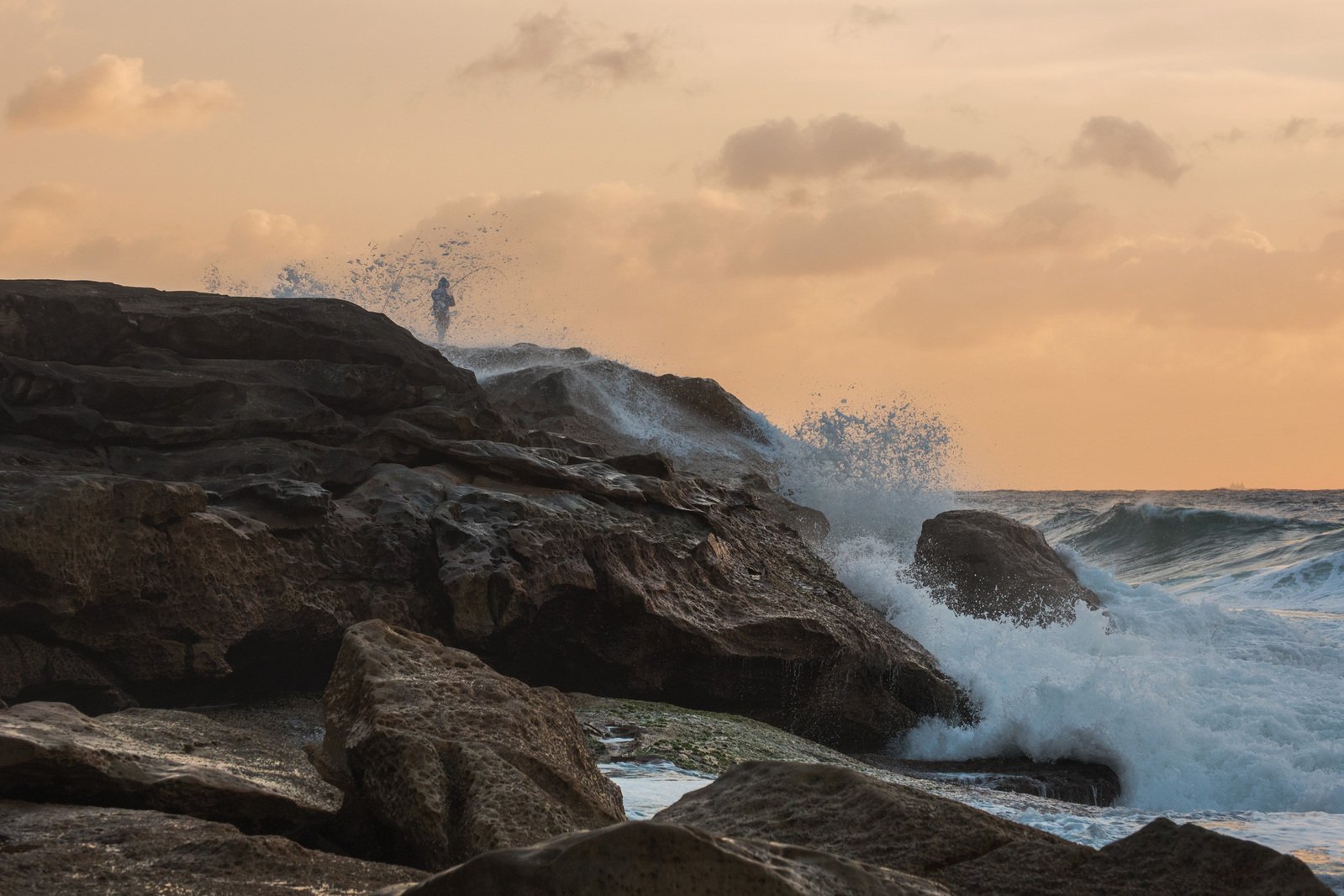 Rock fishing on the cliff with big waves