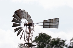 Fins and tailplane of a mechanical windmill against overcast sky