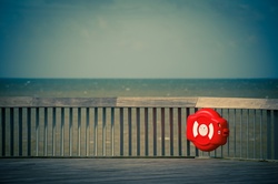 Red lifebuoy on a wooden pier