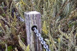 Wooden fence post with chain running through it