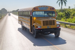 Old yellow school bus on the road in Caribbean
